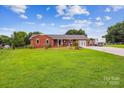 Beautiful brick home on a large, green lot with mature trees and a long driveway at 4527 Marshall Ct, Monroe, NC 28110