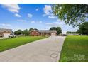 Inviting brick home featuring an extended driveway and well-maintained landscaping at 4527 Marshall Ct, Monroe, NC 28110