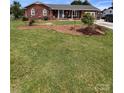 Well-maintained brick home with a spacious front yard featuring lush green grass and mature landscaping at 4527 Marshall Ct, Monroe, NC 28110