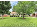 Beautifully maintained ranch home with a manicured lawn, mature trees, and a classic design at 5929 Brookhaven Rd, Charlotte, NC 28210