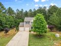 Lovely exterior view of a two-story home with beautiful trees and landscaping, including a long driveway at 6010 Hawk View Rd, Waxhaw, NC 28173