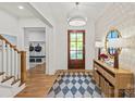 View of the bright foyer featuring hardwood floors, statement lighting, console table, and entry to mudroom at 6013 Camile Ct, Charlotte, NC 28226