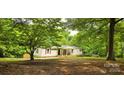 Inviting one-story home with a covered porch, red shutters, and a yard with mature trees at 6140 Barclay Ln, Clover, SC 29710