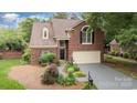 Charming brick home featuring a manicured lawn, two-car garage, and inviting front entrance at 7031 Walton Heath Ln, Charlotte, NC 28277
