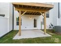 New construction patio with a wooden ceiling cover, concrete base, and sliding glass doors at 9214 Delancey Ln # 62, Concord, NC 28027