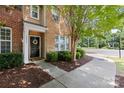 Inviting home entrance with a black door, manicured shrubs, and a sidewalk at 10027 Juniper Trace Dr, Charlotte, NC 28277