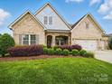 Charming brick home with a well-manicured lawn, beautiful landscaping, and a two-car garage at 1004 Fairbanks Ct, Indian Trail, NC 28079