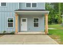 Inviting front porch with natural wood posts, a bright white door, and neat landscaping at 103 Churchill Dr, Kings Mountain, NC 28086