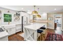 Bright kitchen featuring an island with seating, stylish lighting, white cabinets, and modern stainless steel appliances at 106 Phifer St, Fort Mill, SC 29715