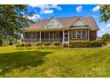 Spacious backyard with a screened porch, lush green grass, and mature landscaping at 1070 Blueberry Rd, Salisbury, NC 28147