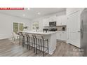 Modern kitchen boasts white cabinetry, stainless steel appliances, and a center island with seating at 11131 Cardinal Creek Ave, Charlotte, NC 28215