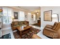 Cozy living room showcasing tile floors, shutters, comfortable seating, and bright natural light at 139 Harper Lee St, Davidson, NC 28036