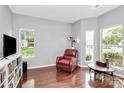 Bright living room filled with natural light, hardwood floors, and a cozy red armchair at 13930 Wild Heather Ct, Charlotte, NC 28273