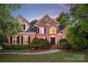 Beautiful brick home with manicured lawn, professional landscaping, and inviting entrance at 15216 Ballantyne Country Club Dr, Charlotte, NC 28277