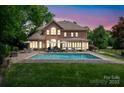 Beautiful backyard oasis with a sparkling pool, lounge chairs, and manicured lawn at 15216 Ballantyne Country Club Dr, Charlotte, NC 28277