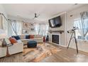 Cozy living room with a fireplace, large windows with patterned curtains, and plush seating at 1708 Speartip Ln, Denver, NC 28037