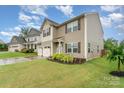 Well-maintained two-story home with a lush green lawn, mature landscaping, and charming curb appeal at 189 Fesperman Cir, Troutman, NC 28166