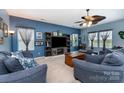 Comfortable living room featuring stylish blue walls, plush seating, and a modern entertainment center at 189 Fesperman Cir, Troutman, NC 28166