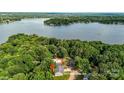 Aerial view of a home nestled among trees with a lake in the background at 2027 Marquesas Ave, Tega Cay, SC 29708
