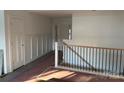 Hallway with a staircase and wooden railing plus modern paneled walls and a neutral color scheme at 2027 Marquesas Ave, Tega Cay, SC 29708