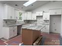 Modern kitchen featuring white cabinetry, stainless steel hardware, granite countertops, and a kitchen island at 2027 Marquesas Ave, Tega Cay, SC 29708