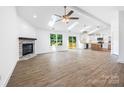 Spacious living room with fireplace, skylights, wood floors, and open access to the kitchen at 2027 Marquesas Ave, Tega Cay, SC 29708