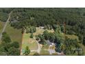 Expansive property featuring a home, a pond, wooded area, and outbuildings, offering privacy and natural beauty at 2291 Howell Rd, Midland, NC 28107