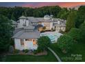 A tranquil swimming pool with an adjoined spa surrounded by pristine landscaping and architectural columns on the patio at 2926 Crane Rd, Waxhaw, NC 28173