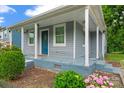 Inviting home with a quaint front porch, complemented by colorful landscaping and a stone walkway at 3400 Reid Ave, Charlotte, NC 28208