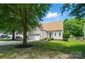 Beautifully landscaped home with mature trees, lush green lawn, and attached garage at 3912 Grace Ct, Indian Trail, NC 28079