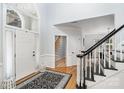 Elegant entryway with a patterned rug, white front door with transom, and a staircase at 4716 Heatherton Pl, Charlotte, NC 28270