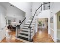 Bright two-story foyer with hardwood floors, staircase with black and white railing, and open sightlines at 4716 Heatherton Pl, Charlotte, NC 28270