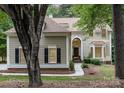 Inviting home exterior with a red front door, arched transom window, and well-manicured landscaping at 4716 Heatherton Pl, Charlotte, NC 28270