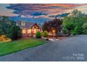 Charming home with stone accents, inviting porch, and beautifully landscaped front yard at sunset at 560 Blue Sky Dr, Dallas, NC 28034