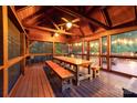 Cozy screened porch with wooden table and benches, offering a relaxing outdoor dining space at 560 Blue Sky Dr, Dallas, NC 28034