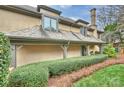 Side view of a tan home with a gray roof and mature, manicured landscaping at 5721 Ballinard Ln, Charlotte, NC 28277