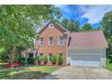 Beautiful two-story brick home featuring a well-manicured lawn and attached two-car garage at 6310 Trevor Simpson Dr, Indian Trail, NC 28079