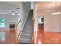 Bright foyer with hardwood floors, staircase, and views into the living room and dining room at 6310 Trevor Simpson Dr, Indian Trail, NC 28079