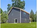 Rear view of a two-story home with a spacious, well-maintained lawn and sliding glass doors at 737 Oak St, Charlotte, NC 28214