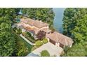 Lakefront home with expansive windows, tile roof, multiple garages, manicured grounds, and waterfront access at 9184 Greenwood Rd, Terrell, NC 28682