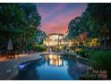 Outdoor oasis featuring a large pool, stone waterfall, lounge chairs, and lush landscaping at 9184 Greenwood Rd, Terrell, NC 28682