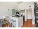 Charming kitchen with pale green cabinets, stainless steel appliances, and bar seating for a modern touch at 115 E Park Ave # 409, Charlotte, NC 28203