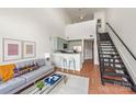Open-concept living area with modern decor, a sleek staircase, and a breakfast bar for casual dining at 115 E Park Ave # 409, Charlotte, NC 28203