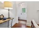 Bright foyer featuring hardwood floors and a marble topped table with lamp as you enter at 1219 Pinecrest Ave, Charlotte, NC 28205
