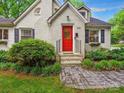 Close up view of a painted brick home featuring a bright red front door and a brick walkway at 1219 Pinecrest Ave, Charlotte, NC 28205