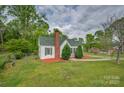 Charming single-story home with green roof, tidy landscaping, and a chain-link fence at 123 N Poston St, Shelby, NC 28150