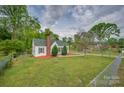 Single-story home featuring green lawn, chain-link fence and mature trees at 123 N Poston St, Shelby, NC 28150