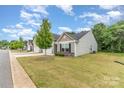 Landscaped lawn of a charming single-story home with lush grass, trees and well-maintained flowerbeds at 1405 Amberlight Cir, Salisbury, NC 28144