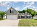 Charming gray home featuring a two-car garage and a well-manicured front lawn at 1533 Moss Creek Dr, Harrisburg, NC 28075