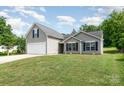 Well-maintained home boasts a two-car garage, complemented by a lush, green front lawn at 1533 Moss Creek Dr, Harrisburg, NC 28075